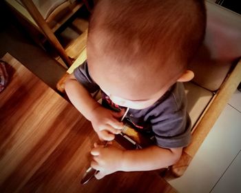 High angle view of boy holding hardwood floor at home