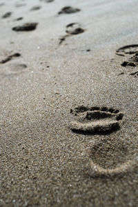 High angle view of footprints on sand at beach