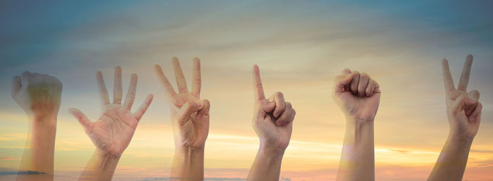 Multiple image of hand gesturing against sky during sunset