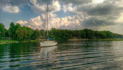 Boats in sea against cloudy sky
