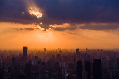 Aerial view of buildings against sky during sunset