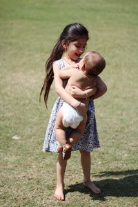 Happy sister and brother on field