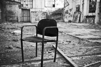 Empty chairs against abandoned building in city
