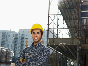 Portrait of young man standing against built structure