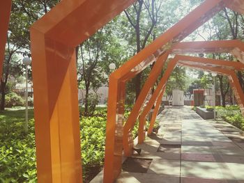 Walkway amidst trees against sky