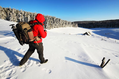 Full length rear view of person standing on snow covered landscape