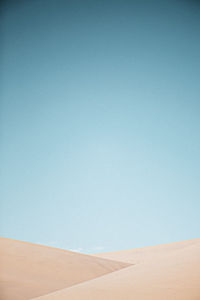 Scenic view of desert against clear blue sky