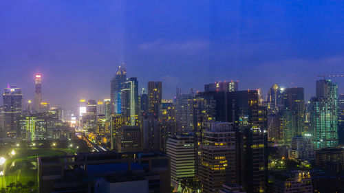 Illuminated cityscape against sky at night