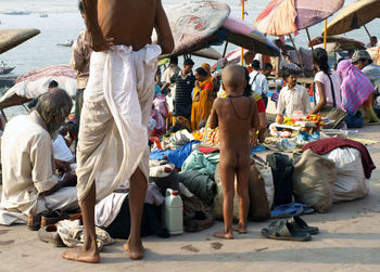 People at riverbank in city