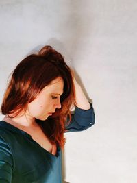 High angle view of woman looking away while standing against wall