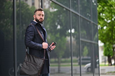 Full length of young man using mobile phone