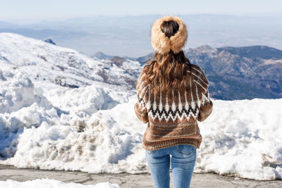 Rear view of woman looking at mountains during winter