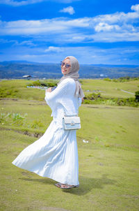 Portrait of woman standing on field