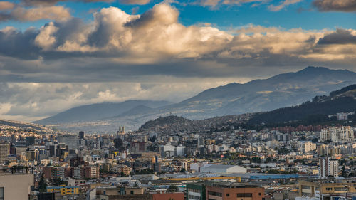 Cityscape against cloudy sky during sunset