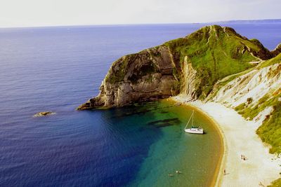 High angle view of cliff by sea against sky