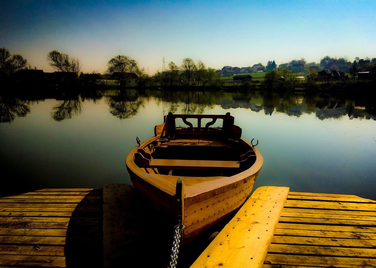 BOAT MOORED AT PIER AGAINST SKY DURING SUNSET