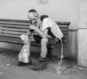 Man sitting on chair against wall