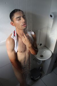 Midsection of man sitting in bathroom