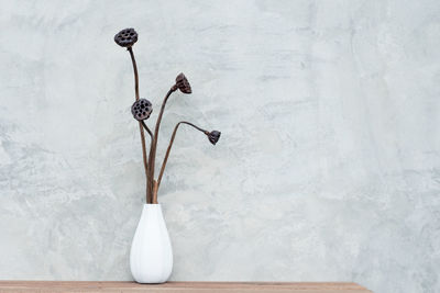 Close-up of white vase on table against wall