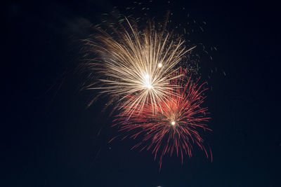 Low angle view of firework display at night