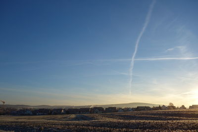 Scenic view of agricultural field against blue sky