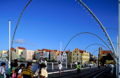 People on street in city against clear blue sky