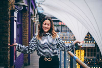 Portrait of smiling young woman standing outdoors