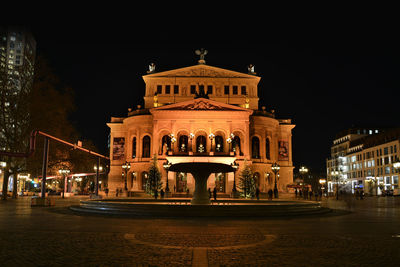 Statue in city at night