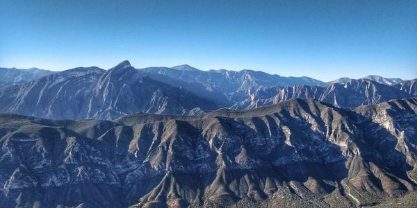 Scenic view of snowcapped mountains against clear blue sky