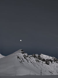 Scenic view of snow covered mountains against sky at night