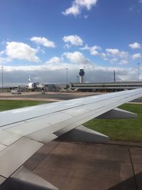 Airplane on airport runway against sky