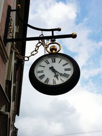 Low angle view of old clock on building against sky