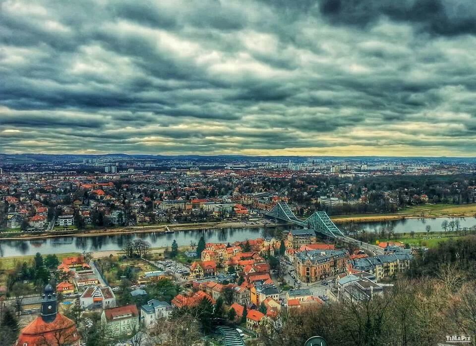 architecture, sky, cloud - sky, cityscape, built structure, building exterior, city, cloudy, river, high angle view, crowded, residential district, cloud, residential structure, water, residential building, weather, overcast, bridge - man made structure, dramatic sky