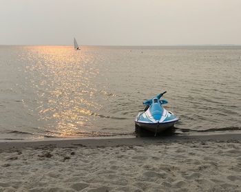 Boat moored on shore against sky