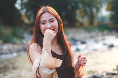 Portrait of smiling young woman standing outdoors