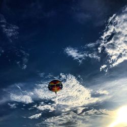 Low angle view of paragliding against blue sky