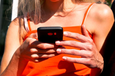 Midsection of woman using mobile phone