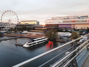 High angle view of ferris wheel by river against sky