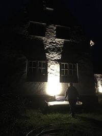 Rear view of silhouette people standing in illuminated building