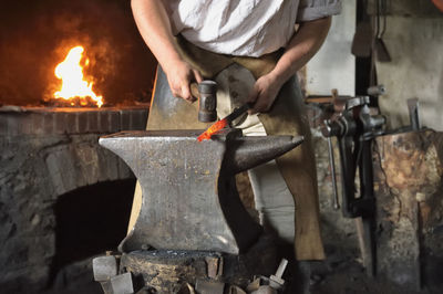 Midsection of man working on metal at workshop