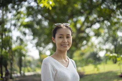 Portrait of smiling woman standing at park