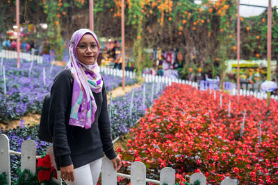 Portrait of smiling woman standing by plants