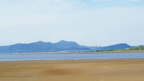 Scenic view of sea and mountains against sky