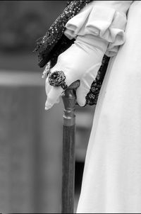 Close-up of woman wearing ring and glove holding stick