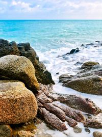 Rocks on beach against sky