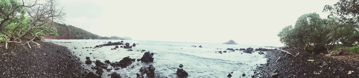 Panoramic view of people on beach against sky