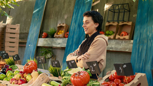 Portrait of young woman holding food at market stall