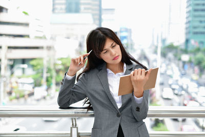 Young woman using mobile phone in city