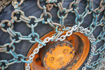 Close-up of rusty chain tied up on metal