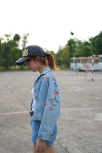 Side view of a young woman standing outdoors